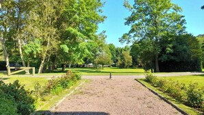 Un sendero de grava que lleva a un parque con bancos y árboles.