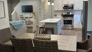 A modern kitchen with white cabinets, stainless steel appliances, and a central island.