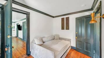 A bedroom with a bed, a door, and a hallway.
