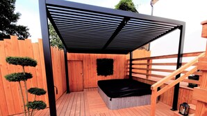 A wooden deck with a covered seating area, a staircase, and a small tree. - At the water's'edge "Nymphea (Saint-Barthelemy)