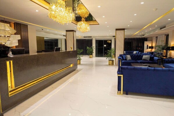 A modern hotel lobby with a reception desk, seating area, and decorative lighting. - Envoy Continental Hotel, Blue Area, Islamabad (Islamabad)