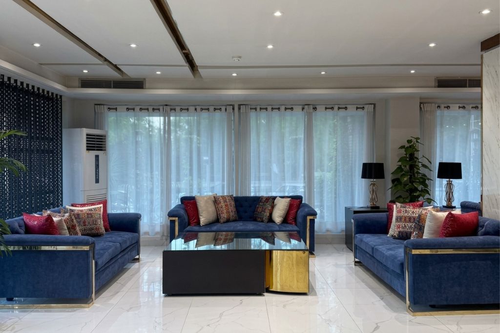 A modern living room with two sofas, a coffee table, and a large window with curtains.