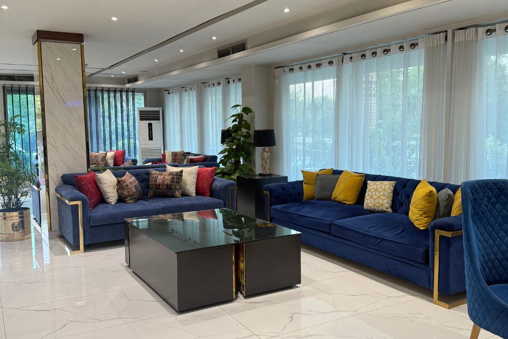 A modern living room with two sofas, a coffee table, and a potted plant.