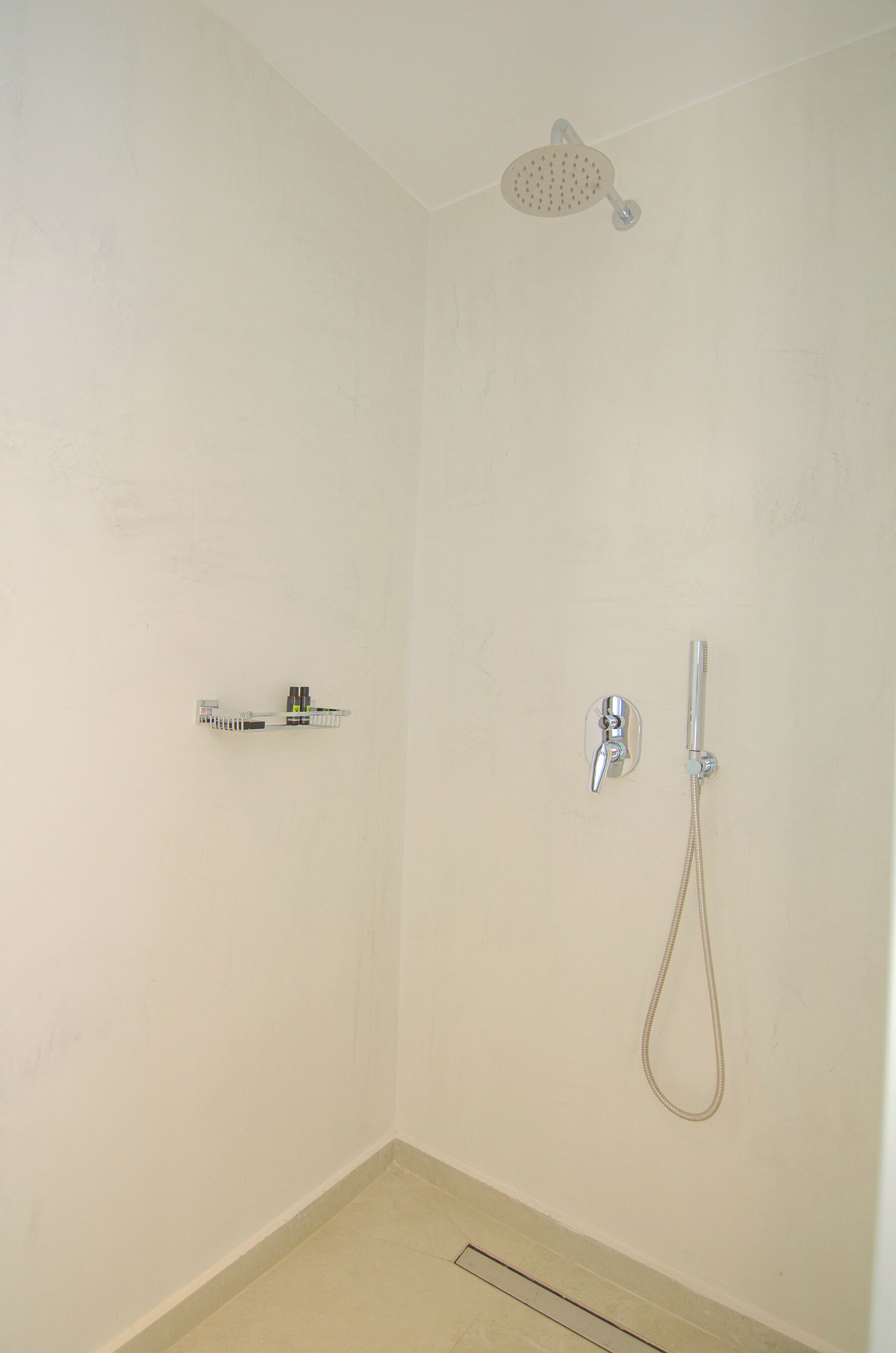Une salle de bain avec une douche, des toilettes et un porte-serviettes.