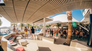 A poolside area with lounge seating and a crowd of people. - FarOut BeachClub - Rooms & Camping (Ios)