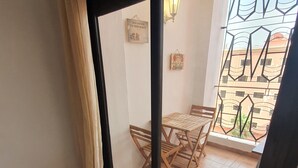 Ein Zimmer mit einer Schiebetür und einem Außenbalkon mit Tisch und Stühlen.