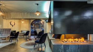 A modern interior with a fireplace, seating area, and unique ceiling light fixtures.