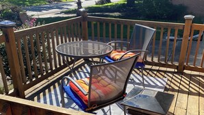 A wooden deck with a metal table and chairs, surrounded by a wooden railing. - Charming East Dallas Home (Dallas)