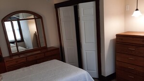 Een slaapkamer met twee bedden, een kaptafel, een spiegel en een deur.