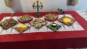 A table with various food items and a candelabra with candles. - Auberge Château Bahia (Escuminac)