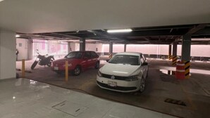 Un parking couvert où deux voitures sont stationnées.