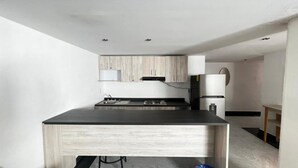 Une cuisine moderne dotée d’un îlot central, de meubles de rangement intégrés et d’un réfrigérateur.
