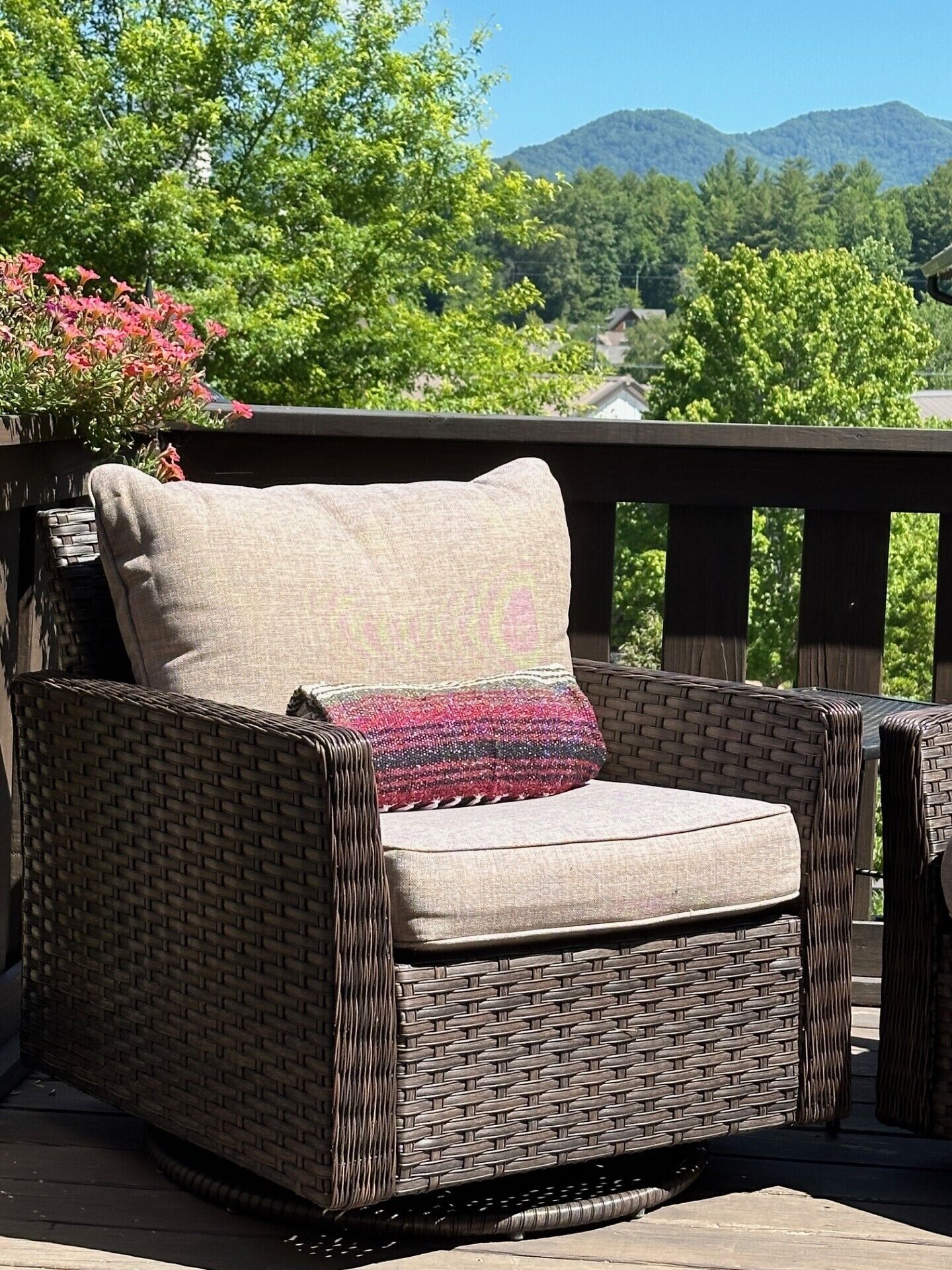 Ein Korbstuhl mit Kissen auf einer Terrasse.