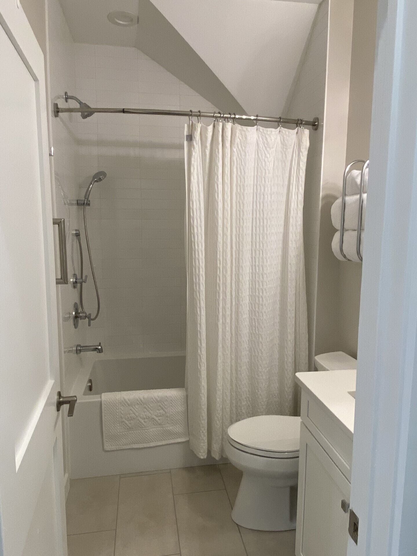 A bathroom with a shower, toilet, and bathtub.