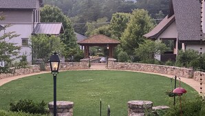 A courtyard with a gazebo, stone walls, and a lawn. - Studio in upscale, intimate Black Mountain neighborhood (Black Mountain)