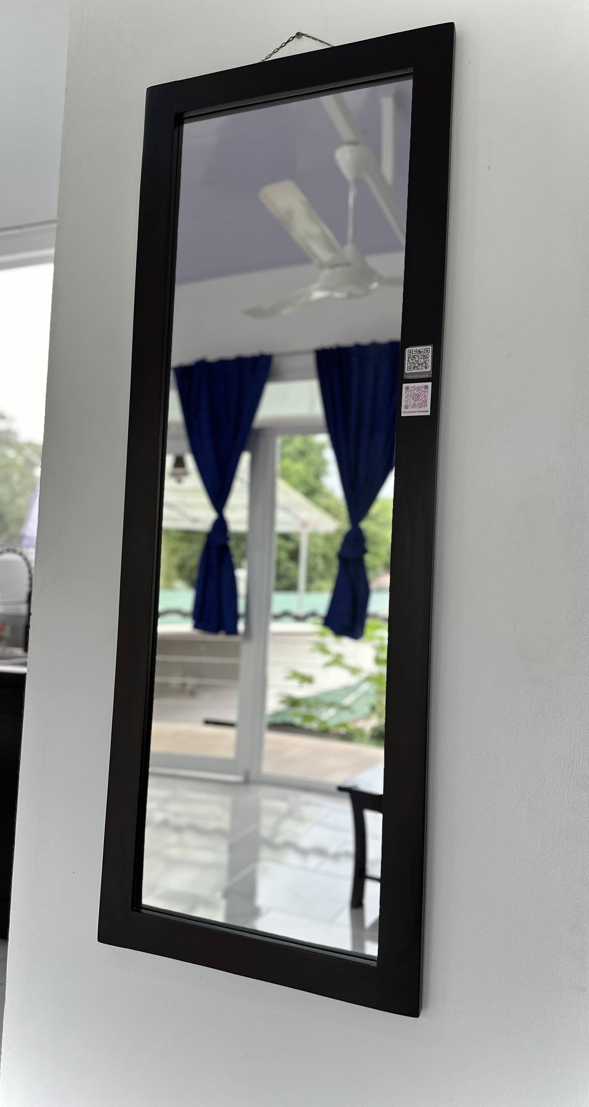 A framed mirror with a QR code on the wall.