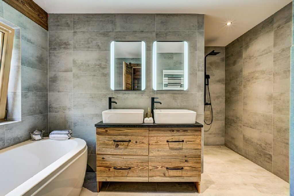 A modern bathroom with a freestanding bathtub, double sinks, and a walk-in shower.
