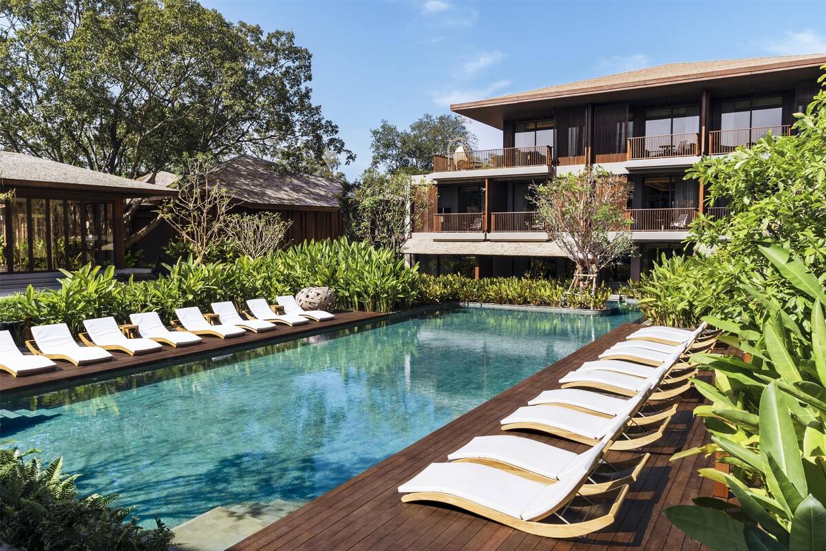 Un espace piscine avec des chaises longues et une terrasse en bois.