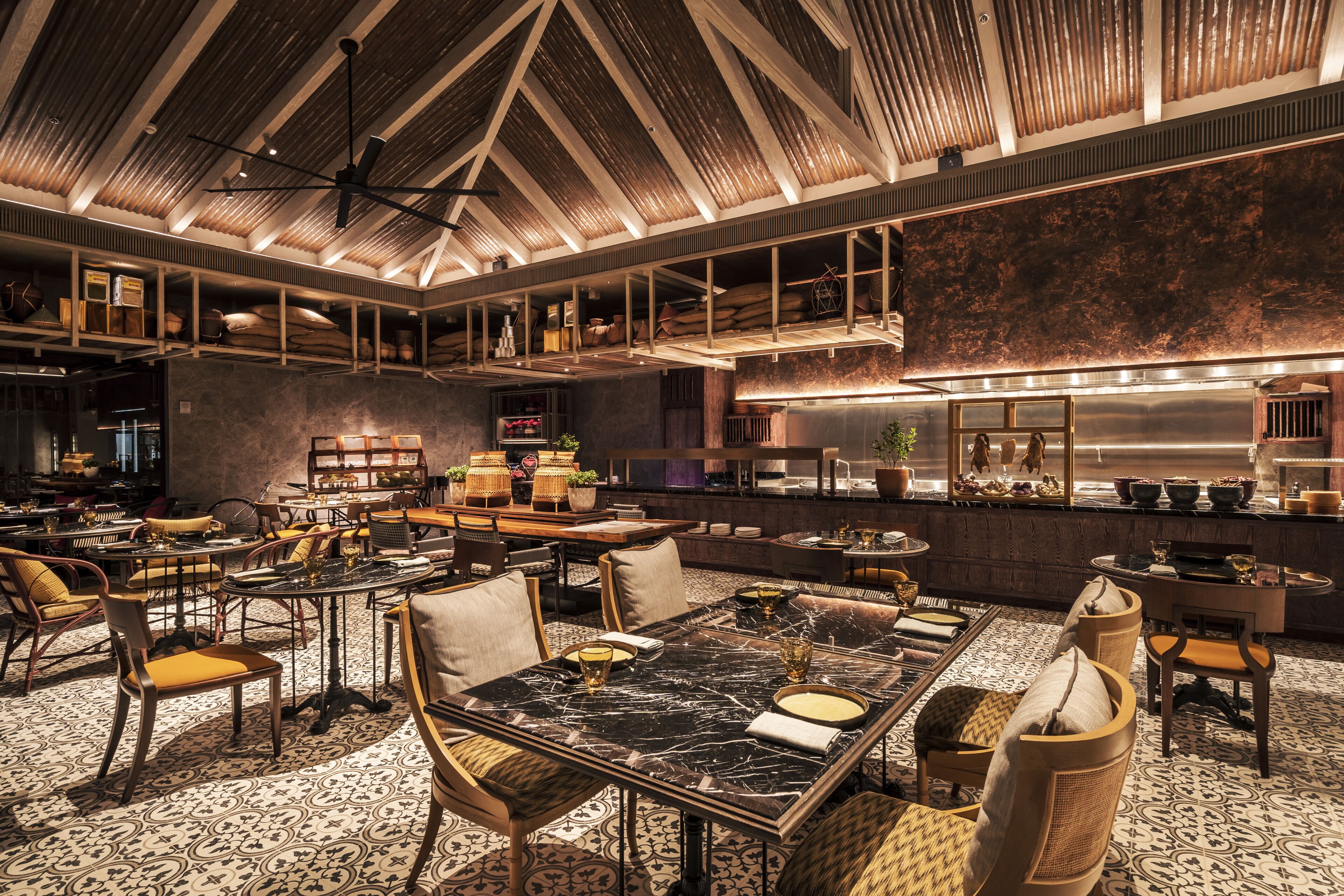 A spacious restaurant with high ceilings, exposed beams, and a variety of seating arrangements including tables and chairs.
