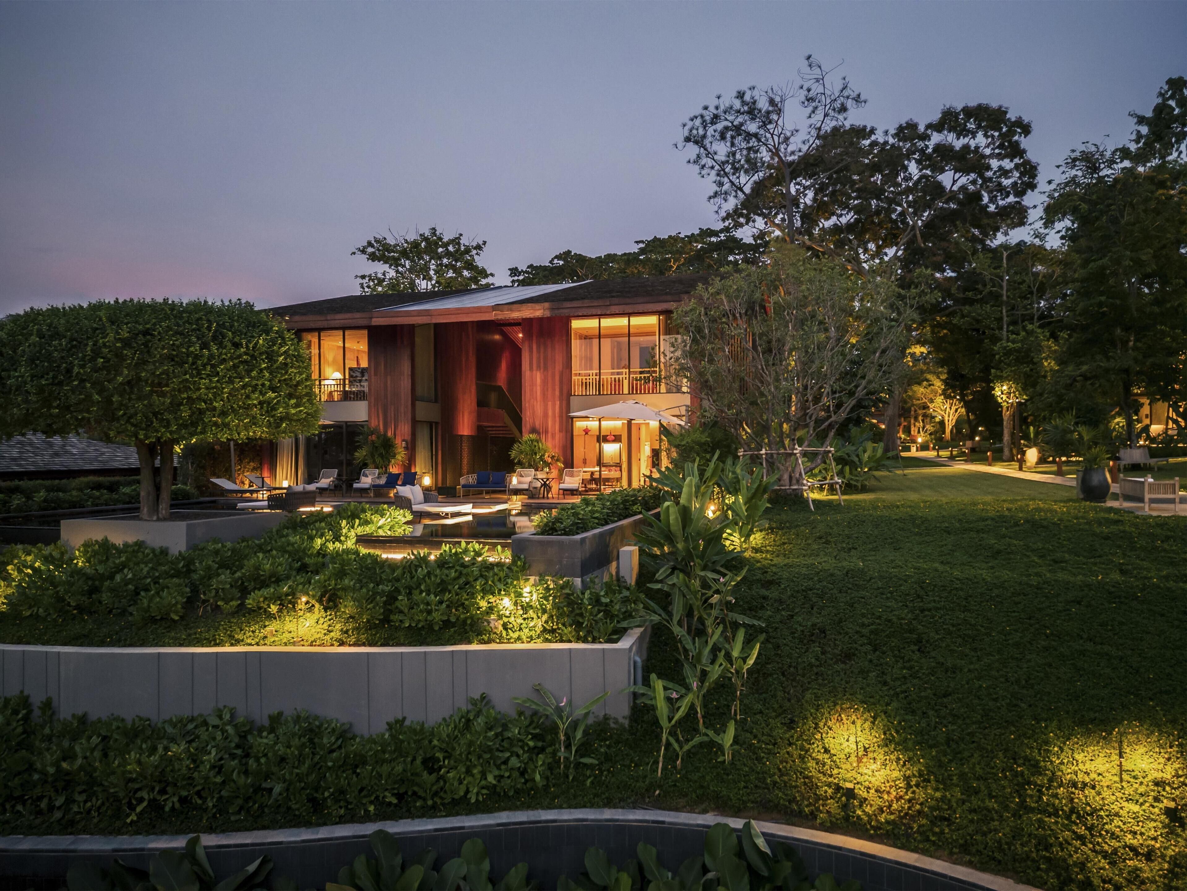 A modern house with a spacious outdoor area, including a pool and seating.