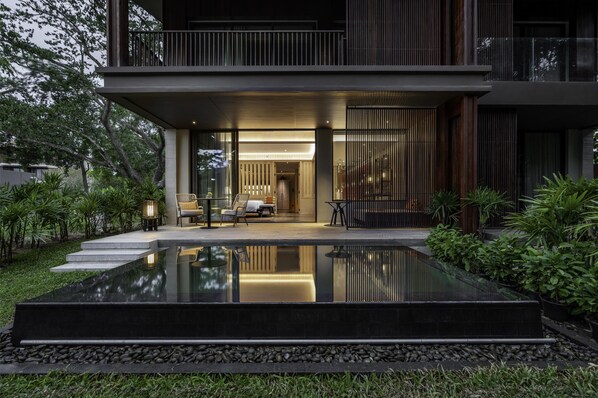 Een modern huis met een zwembad, terras en een verzorgde tuin.