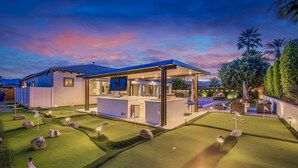 A golf course with a clubhouse, well-maintained grass, and a clear sky. - The Montage: Luxury Resort Desert Retreat (Indio)