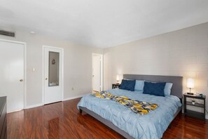 A bedroom with a large bed, a nightstand, a door, and a wall-mounted shelf. - Oasis Paradise in Arcadia | Pool+Hot Tub | Views! (Phoenix)