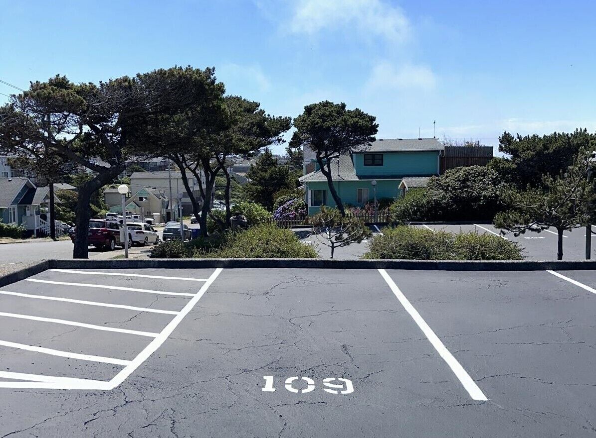 Un parcheggio con posti delimitati e un edificio sullo sfondo.