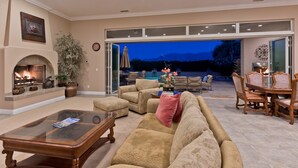 A spacious living room with a fireplace, comfortable seating, and a view of the outdoors.