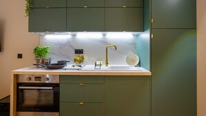 A kitchen with a built-in oven, a sink, and a countertop with various kitchen items.