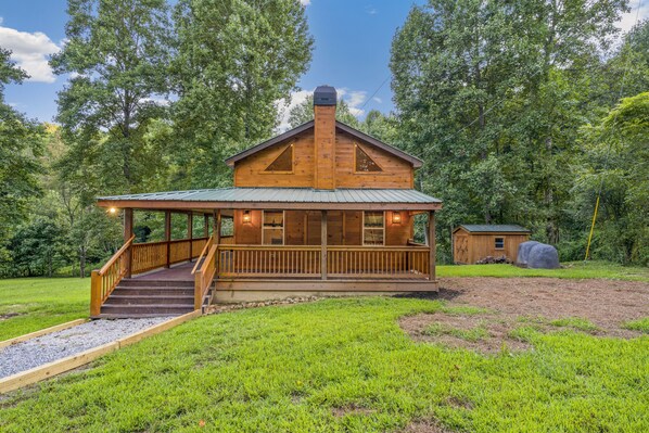 A wooden cabin with a porch, a small shed, and a covered area. - Mountain-side Cabin with hot tub on 4 acres! (Cherry Log)