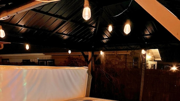 A hot tub with a control panel and a wooden deck surrounding it.