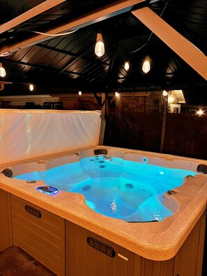 Un bain à remous doté d’un panneau de commande et entouré d’une terrasse en bois.