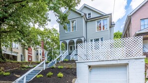 A two-story house with a white garage and a white picket fence.