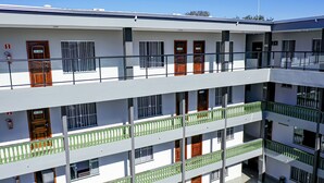 A multi-story building with balconies, fire extinguishers, and numbered doors. - Vila Nóbrega Residencial (Foz do Iguaçu)
