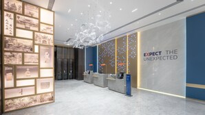 A modern reception area with a large wall displaying historical photographs and a slogan. - Holiday Inn Express Chengdu Pidu by IHG (Chengdu)