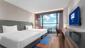 A hotel room with two beds, a desk, a chair, a TV, and a large window with a city view. - Holiday Inn Express Chengdu Pidu by IHG (Chengdu)