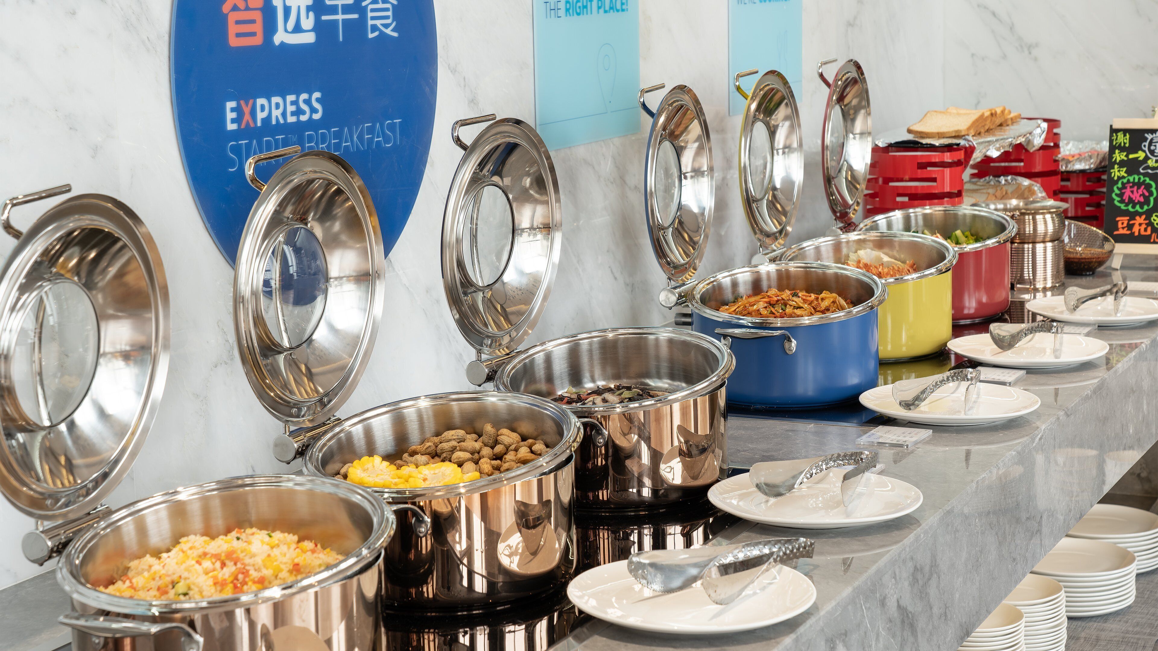 Un buffet avec différents plats et ustensiles de service.