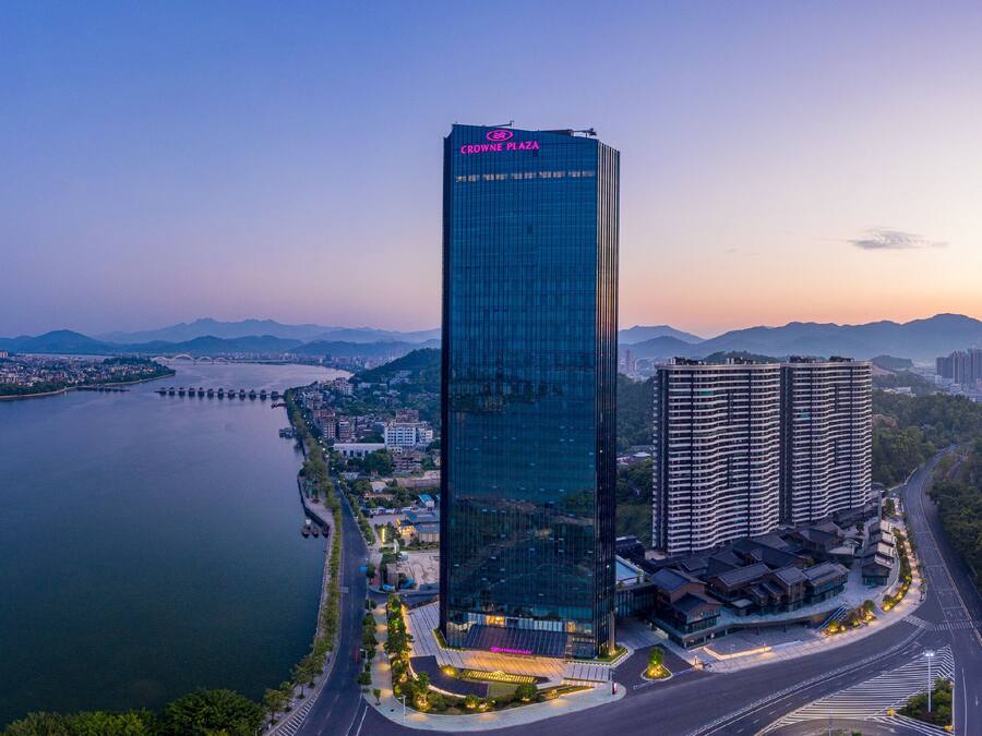 A high-rise building with a glass facade and a sign reading 'CROWN PLAZA'.