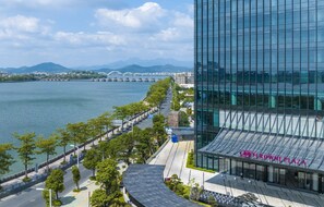 A modern building with a glass facade and a sign reading 'CROWN PLAZA'. - Crowne Plaza Chaozhou Riverside by IHG (Chaozhou)