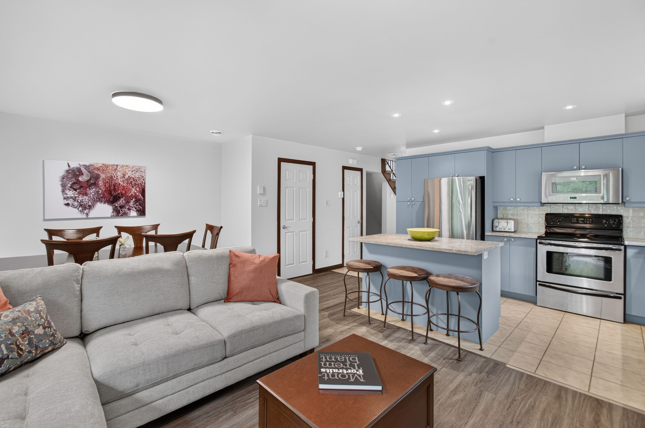 A modern apartment with a living room, dining area, and kitchen.