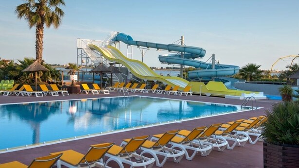 Uma piscina com vários toboáguas e espreguiçadeiras.