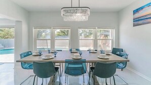 Un espace repas comprenant une grande table, des chaises et un lustre.