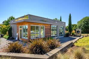 Un bâtiment moderne doté de grandes fenêtres, d’une façade en bois et d’une enseigne portant le mot « albit ».