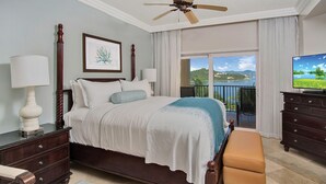 A bedroom with a bed, a nightstand, a dresser, a television, and a balcony with a view.