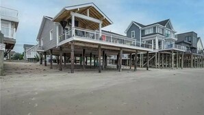 A beachfront property with a wooden deck and a balcony.