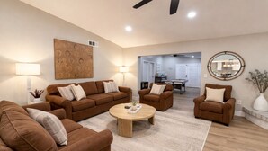 Ein modernes Wohnzimmer mit braunen Sofas, einem Couchtisch und einem Billardtisch.