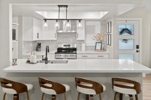 Updated open kitchen with quartz countertops, a modern island, and seating for four. - 5BR Scottsdale Luxury Pool Home w Hot Tub (Scottsdale)