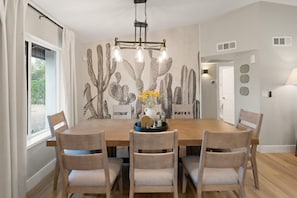 Dining table set for six under a statement chandelier and framed by a desert cactus wallpaper. - 5BR Scottsdale Luxury Pool Home w Hot Tub (Scottsdale)