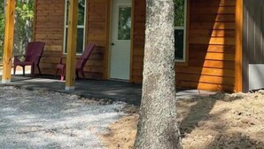 A wooden cabin with a porch, two doors, and two windows. - Nostalgic Route 66 Cabin with Meramec River Access (Bourbon)